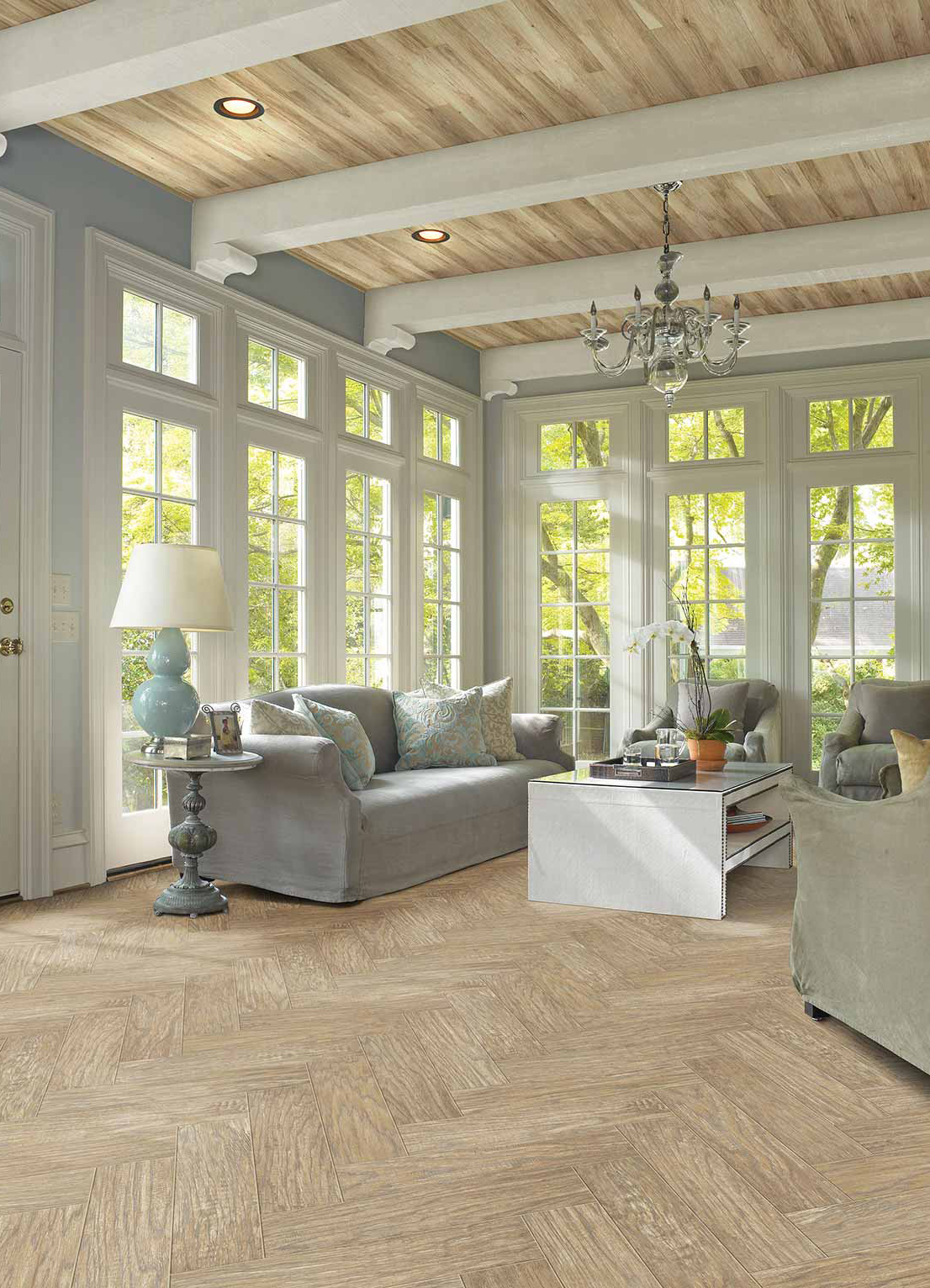 Grand Summit Laminate by Shaw Floors. Featuring bright, living room scene with french windows, gray furnishings and rustic beam ceiling